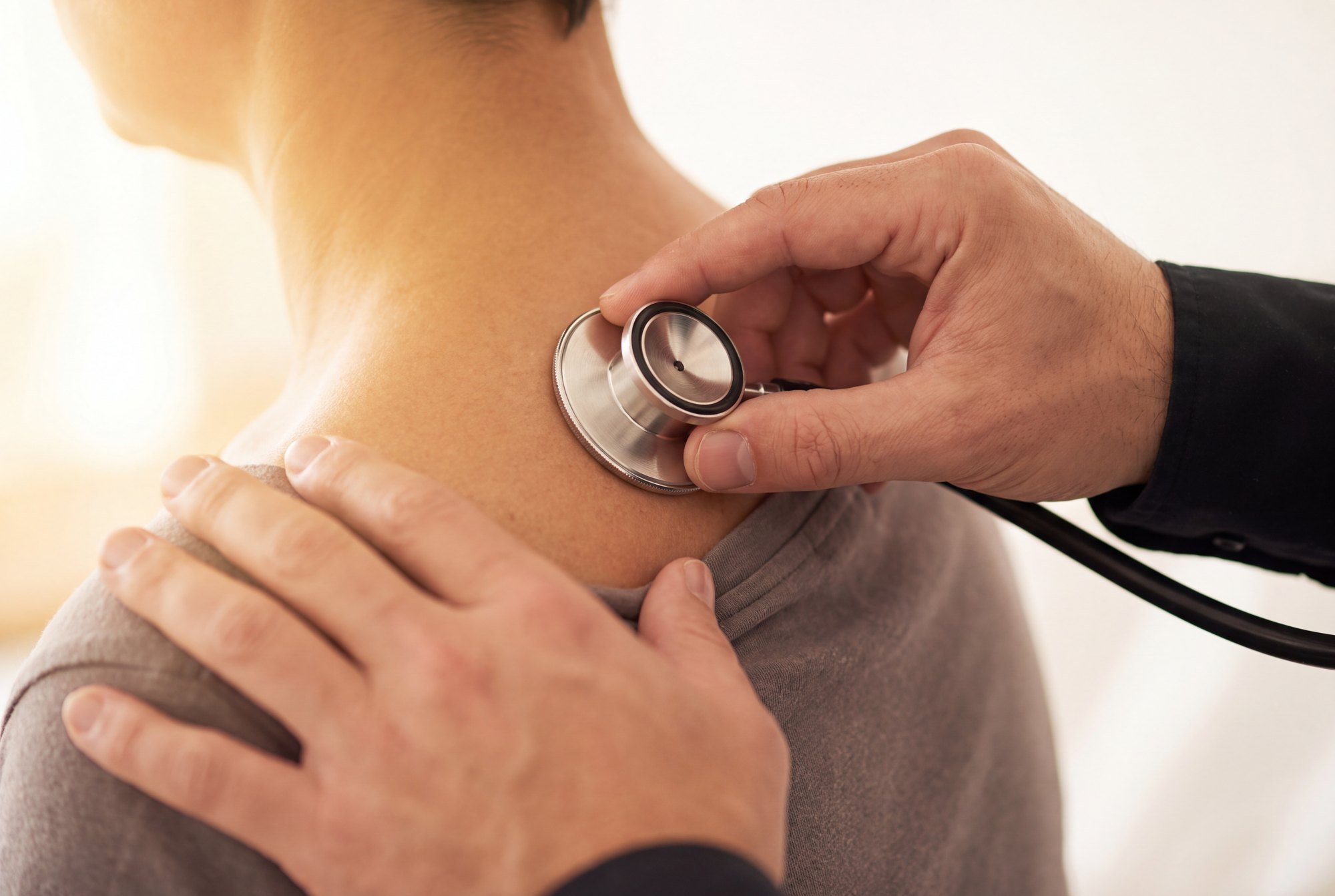 Clinician listening to a patient’s lungs with a stethoscope
